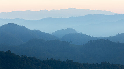 Natural scene of hazy blue mountain range of tropical rainforest.
