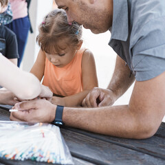 Obraz premium dad and daughter spend time together. cute caucasian girl takes part in a master class for making paper crafts