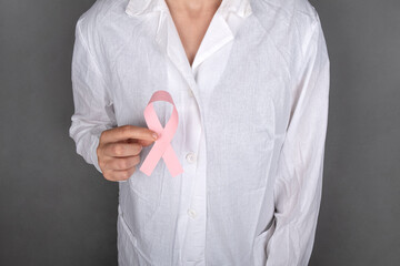 doctor holding a pink ribbon symbol of the fight against breast cancer.