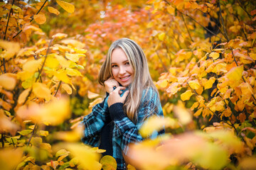 Fall portrait of a beautiful young woman in a knitted warm sweater on a bright sunny day. Autumn concept.