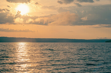 Fototapeta premium The sun's rays break through the dark clouds after a storm over the river.