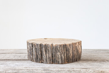 Old wood with a white wall behind, natural, natural background for the presentation of cosmetics and product. A close-up of a tree cut with a copy space.
