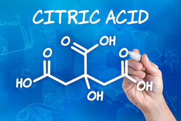 hand with pen drawing the chemical formula of citric acid