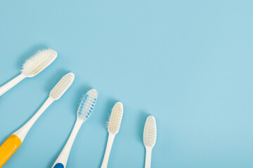 The old toothbrush used expired (damaged) variety of colors on the blue background. concept Used...