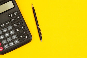 calculator with pen for accountant on yellow background