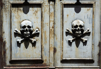 Two mortuary skulls in the door of a cemetery
