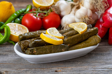 Stuffed Graped leaves with olive oil. on wood floor