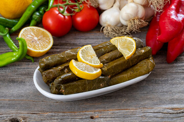 Stuffed Graped leaves with olive oil. on wood floor