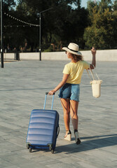 woman in hat with suitcase	