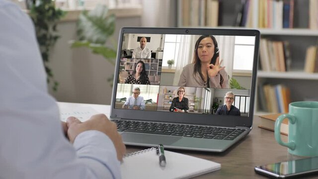 business man works from home in video conference call at the laptop,chinese woman leader conferencing with workgroup of colleagues speaking coaching in the computer screen in online meeting
