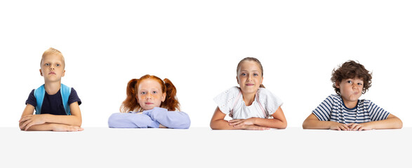 Collage of portraits of little and happy kids, school girls and boys sitting isolated on white studio background. Human emotions, facial expression, back to school concept.