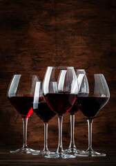 Selection of red wines on tasting. Dry, semi-dry, sweet red wine on old wooden table background