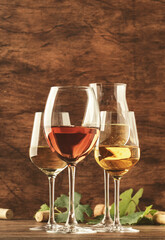 Wine tasting. Red, white, rose and champagne - still and sparkling wines sin glasses on vintage wooden table background