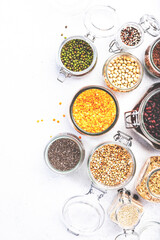 Grocery, home stocks in plastic free storage and jars. Various beans, grains, cereals, legumes, seeds in reusable cans. White table. Zero waste and sustainable llifestyle