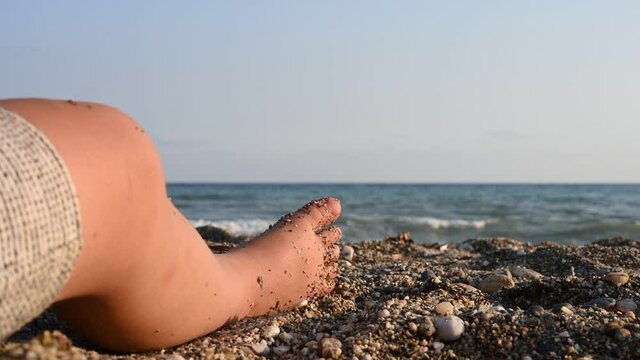 Child's foot on the background of the sea sea 
