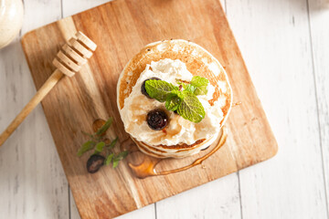 Pile of freshly cooked pancakes with blueberries on white background, morning breakfast meal