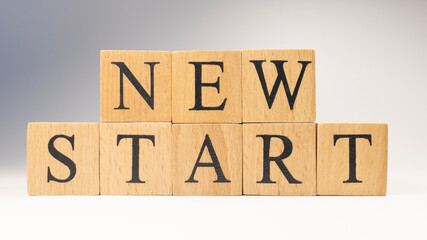 The word new start was created from wooden cubes. life and psychology.