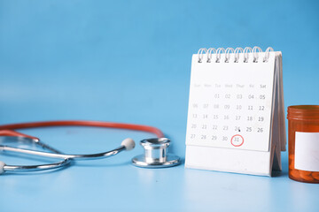 top view of pills and stethoscope on calendar ,