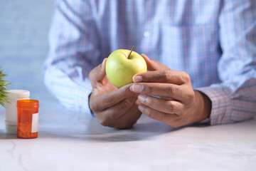 hand holding green apple while sited 
