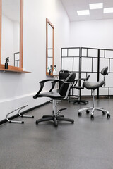 Hairdressers chair and mirror ready to receive visitors. The interior of the salon with hairdressing equipment and furniture.