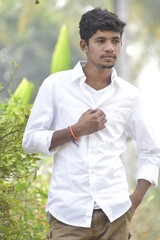 Handsome Men Posing In White T Shirt On Outdoor Nature Background. Men Holding Shirt on Hands. Indian Men  Men Model from Asia. Walking.