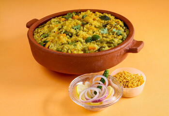 The Delicious Indian 'Kichdi' in a earthen bowl, the dish is prepared with basmati rice, dhals, pulses and green vegetables garnished with mint and coriander leaves.
