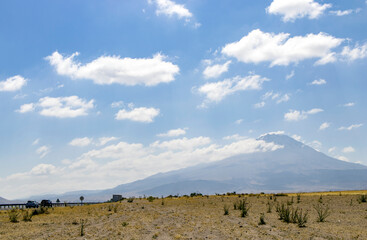 A steep mountain landscape with clouds at the top. Hasan Mountain in Turkey