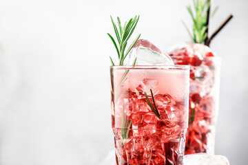 Cranberry cocktail with vodka, ice, juice, rosemary and red berries in highball glass. Refreshing...
