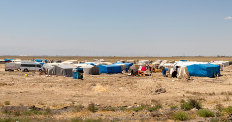 migrant tents, refugee camps. seasonal worker tents in an open area.