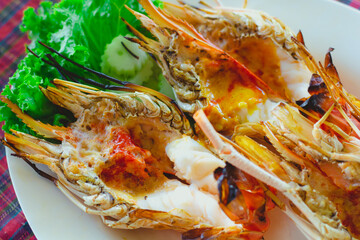 Grilled river giant prawn with spicy seafood sauce in  disk.