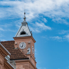 Ein kleiner, Kirchturmartiger Bau mit Uhr auf einem Gebäude in Meran