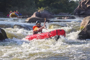 Foto op Canvas A man rowing inflatable packraft on whitewater of mountain river. Concept: summer extreme water sport,  active rest, extreme rafting. © Oleksandra
