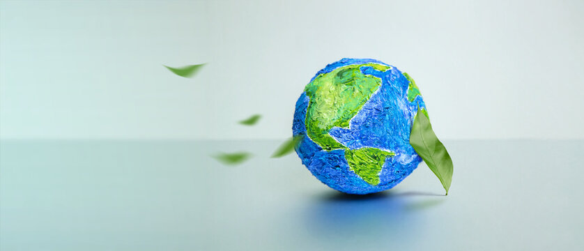 World Earth Day Concept. Green Energy, Renewable and Sustainable Resources. Environmental and Ecology Care. Green Leaf by the Globe