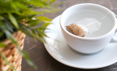 Herbal tea next to the flower pot on the patterned marble