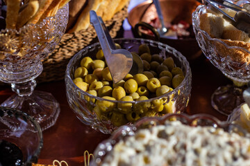 Detalhe de mesa de bufê de festa com diversas opções gastronômicas.