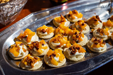Detalhe de mesa de bufê de festa com diversas opções gastronômicas.