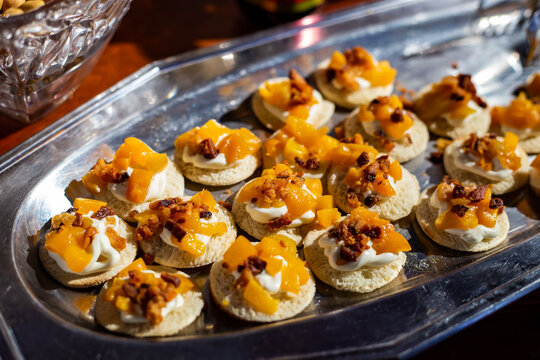 Detalhe de mesa de bufê de festa com diversas opções gastronômicas.