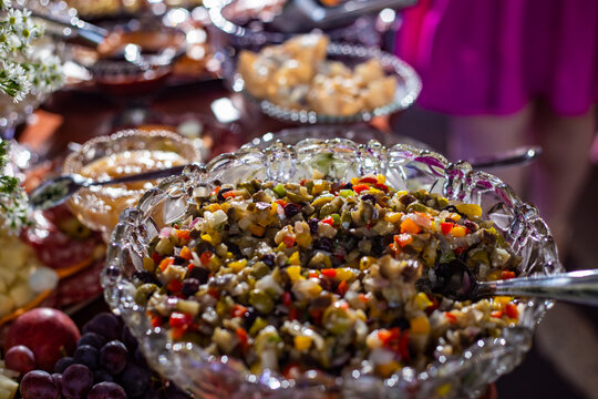 Detalhe de mesa de bufê de festa com diversas opções gastronômicas.