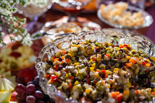 Detalhe de mesa de bufê de festa com diversas opções gastronômicas.