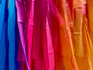 Colored silk ribbons hung in order to form a brightly colored gradient for use as a background decoration