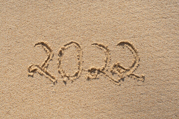 new year 2022 . happy new year number written in the beach sand