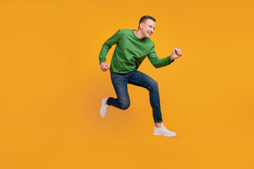Fototapeta na wymiar Profile portrait of energetic athletic guy jump run rush shopping season on yellow background