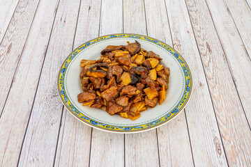 Chinese popular recipe of stewed beef with bamboo and Chinese mushrooms on white plate