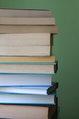 Stack of books with blue and green covers. Selective focus.