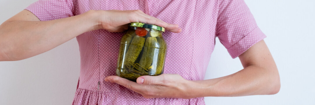 Woman hands holding jar of salty pickles. Organic cucumber