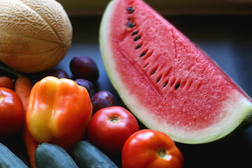 Various colorful summer fruit and vegetable on dark background. Selective focus.