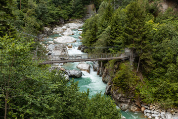 Suspension bridge over the Reuss river with rapids at Gurtnell in German-speaking Switzerland.