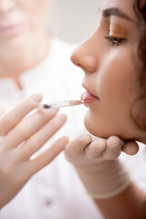 Doctor use syringe for filler lips injections for young woman. Beauty plastic correct augmentation...
