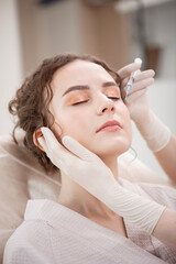 Fototapeta premium Doctor use syringe for filler mimic wrinkles injections for young woman. Beauty plastic correct augmentation procedure.