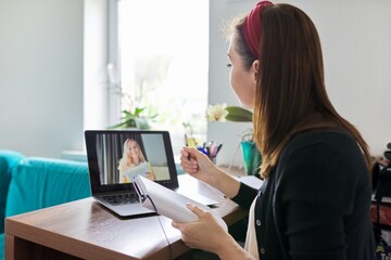 Female teacher at home with laptop on virtual meeting with teenage student